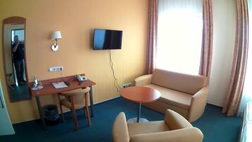 Habitación triple Confort, 1 cama de matrimonio, no fumadores, vistas a la ciudad | Zona de estar | Una televisión