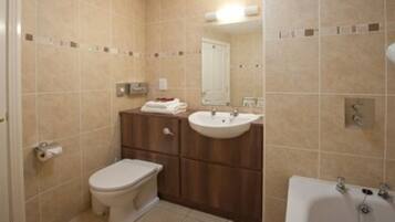 A bathroom with a toilet, sink, and bathtub.