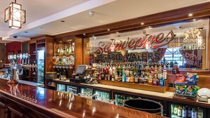 A bar area with a sign reading "Schweppes Table Waters" and a variety of bottled beverages. - Corr's Corner Hotel (Newtownabbey)