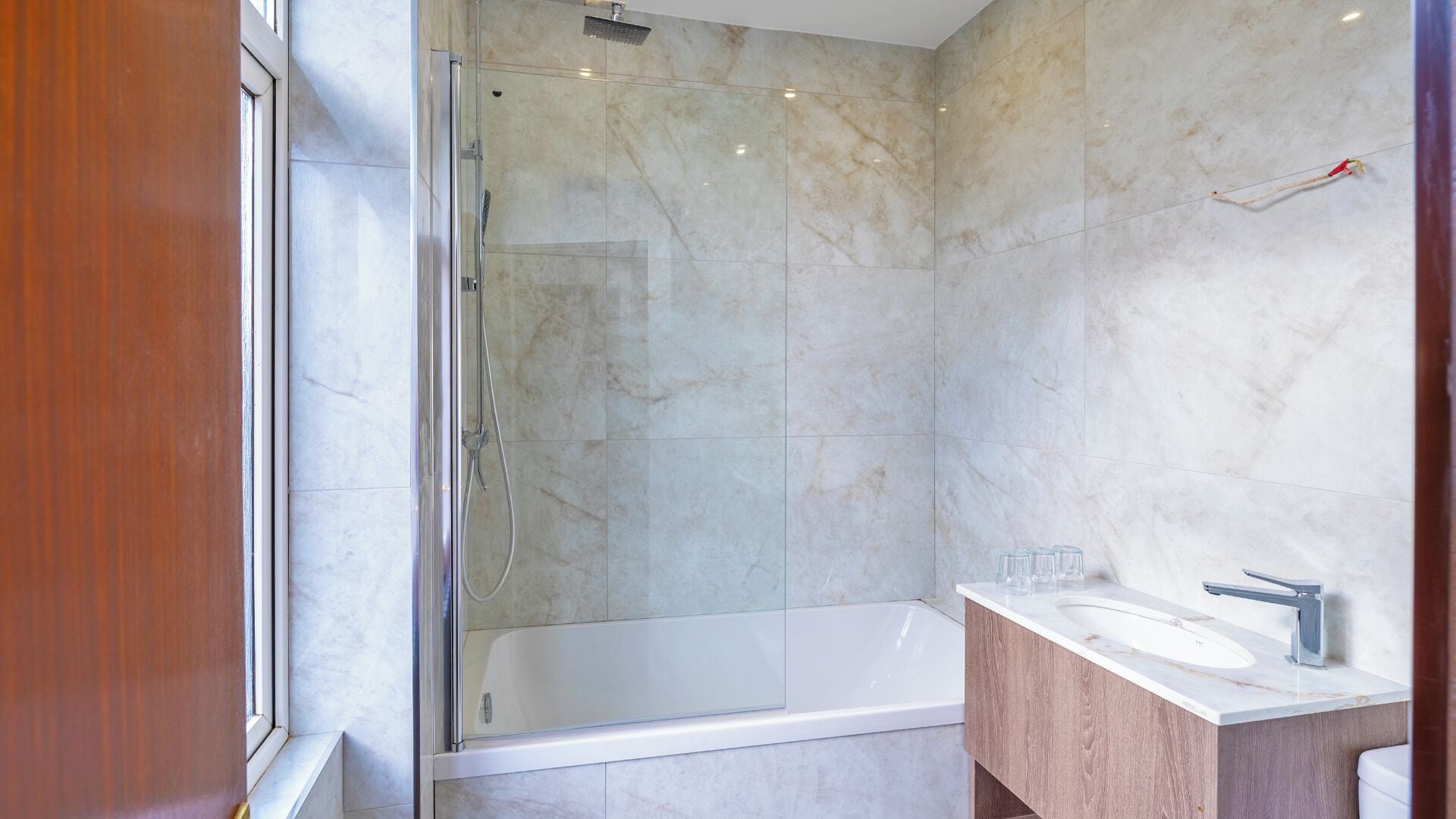 Une salle de bain moderne dotée d’une douche à parois de verre, d’une baignoire sur pieds et d’un meuble-lavabo.