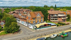 A riverside hotel with a prominent riverside terrace, a traditional brick facade, and a riverside view. - Uno Thames Hotel (Maidenhead)