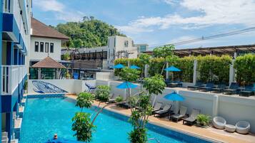 Una piscina al aire libre, camas de piscina gratis, sombrillas