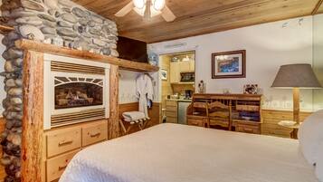 Une chambre confortable avec une cheminée en pierre, des meubles en bois et un lit.