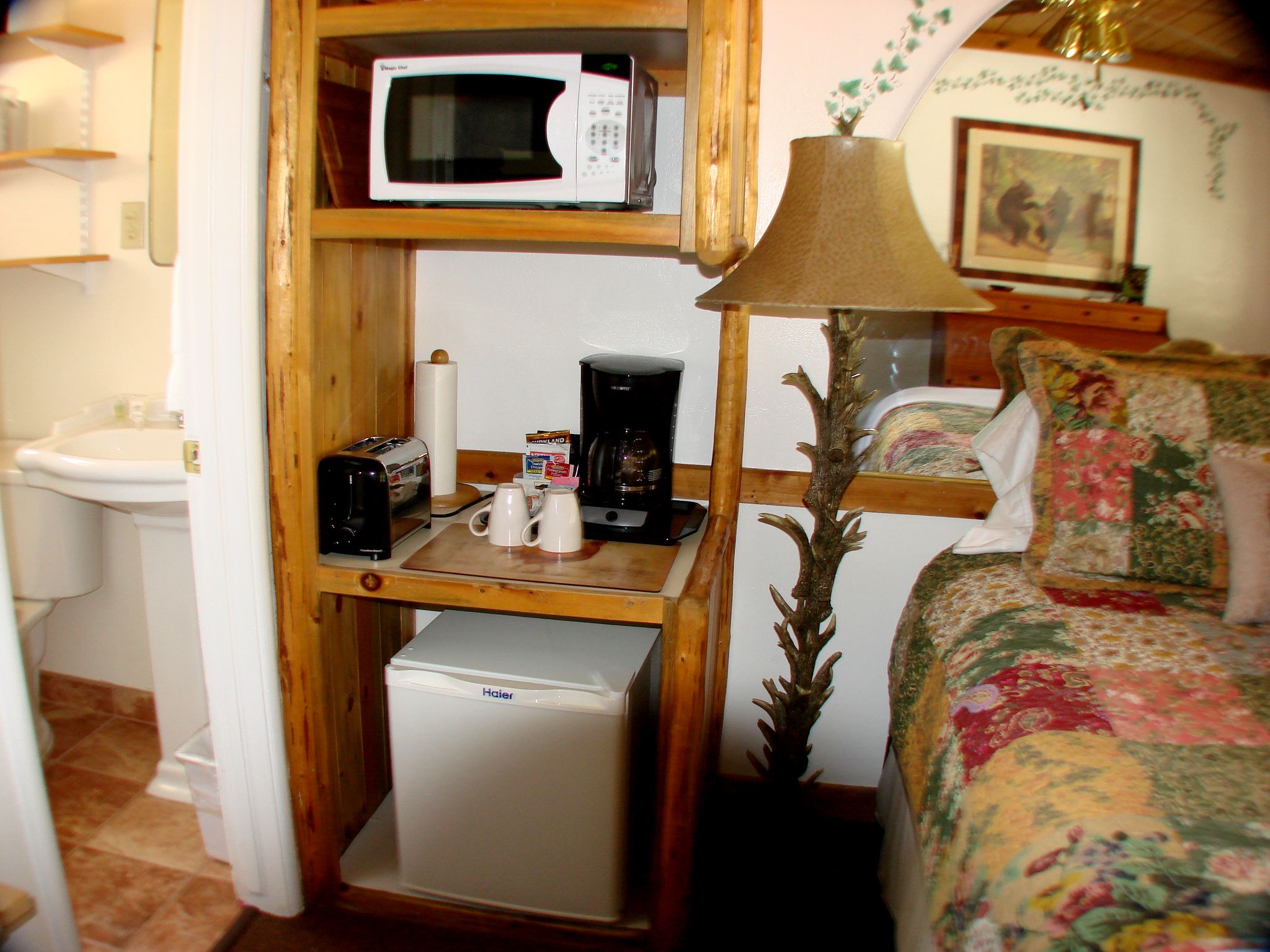 Quarto compacto com micro-ondas, torradeira, máquina de café e pequena geladeira.
