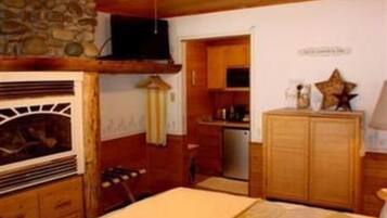 Um quarto aconchegante com lareira, armários de madeira e ventilador de teto.