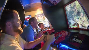 People playing a video game in an arcade setting.