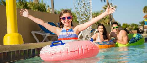 A pool area with inflatable floats and a water feature.
