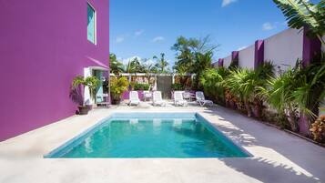 Alberca al aire libre, sombrillas en la alberca y camastros