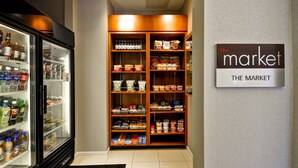 A hotel pantry stocked with beverages and snacks, a refrigerated display case, and a sign reading "The Market". - Residence Inn by Marriott O'Fallon (O'Fallon)