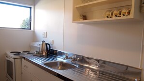 Een moderne keuken met roestvrijstalen apparatuur, een dubbele spoelbak en een raam dat voor natuurlijk licht zorgt.