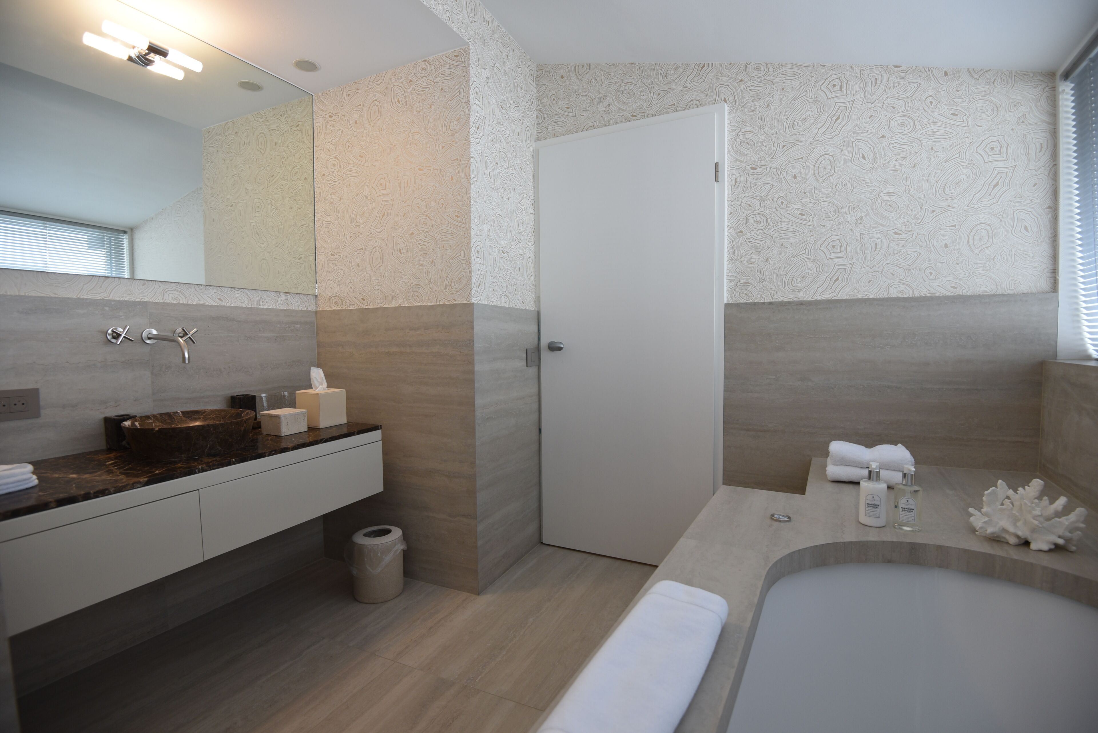 Ein modernes Badezimmer mit einem Marmorwaschtisch, einer Badewanne und einer Duschkabine.