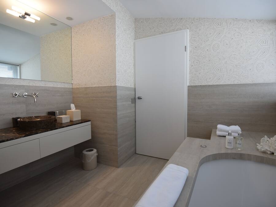 Ein modernes Badezimmer mit einem Marmorwaschtisch, einer Badewanne und einer Duschkabine.