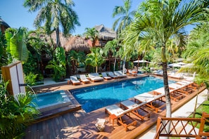 A pool area with lounge chairs and palm trees. - Magic Blue Spa Boutique Hotel-Adult Only (Playa del Carmen)