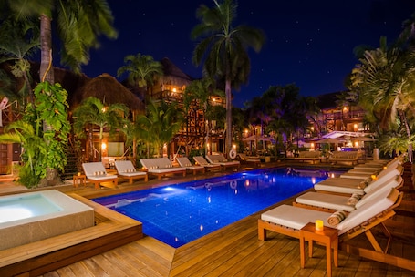 Una piscina al aire libre, sillones reclinables de piscina