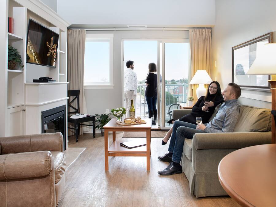 Una sala de estar moderna con un sofá, una mesa de centro y un televisor montado en la pared.