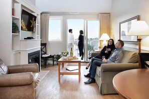 Una sala de estar moderna con un sofá, una mesa de centro y un televisor montado en la pared.