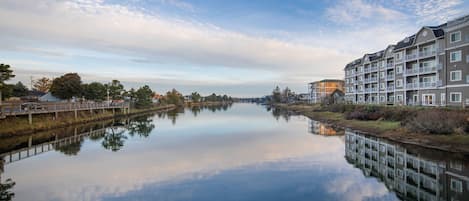 A calm river with a bridge and modern buildings on the right.