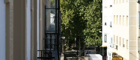 Una calle estrecha con vehículos estacionados y edificios a ambos lados.