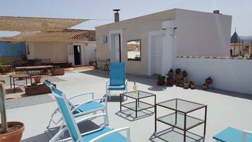 Terraza en la azotea con mobiliario, plantas en macetas y vistas despejadas del entorno.