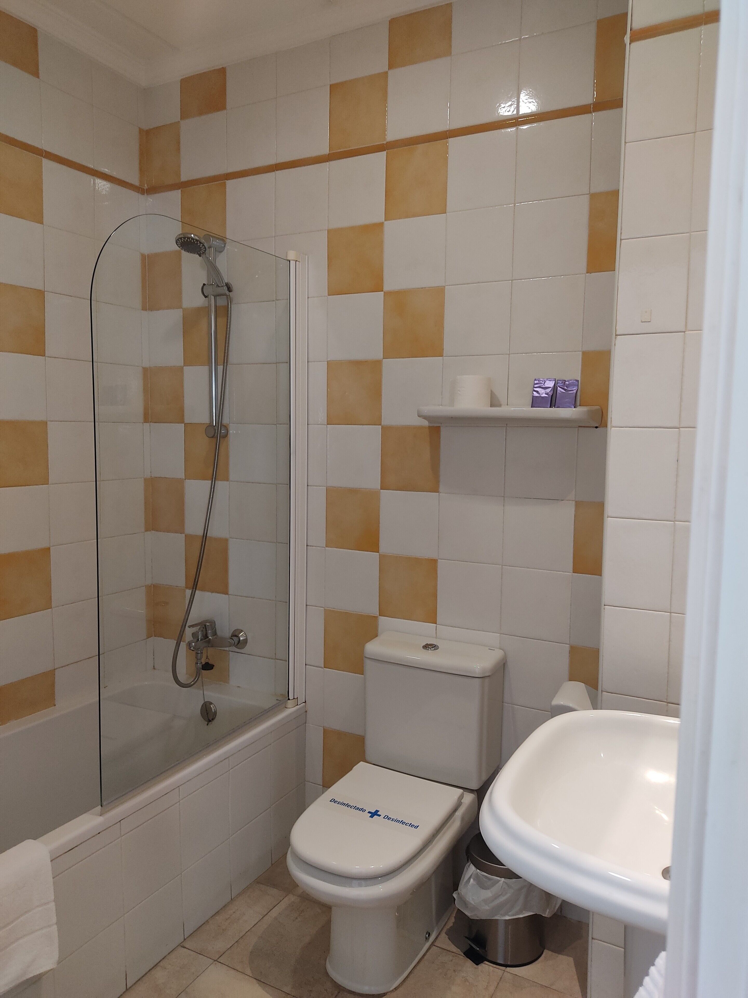 A bathroom with a shower, toilet, and sink.
