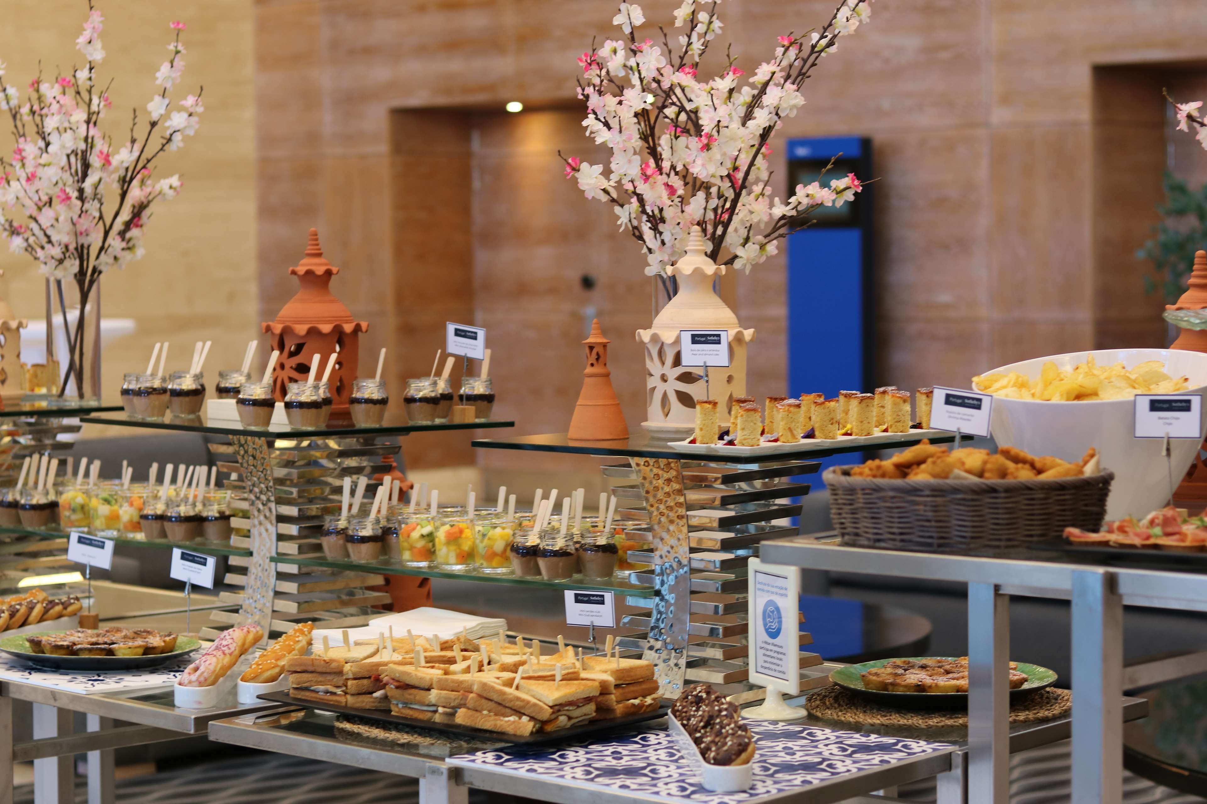 A buffet with various food items and decorative elements like vases and flowers.