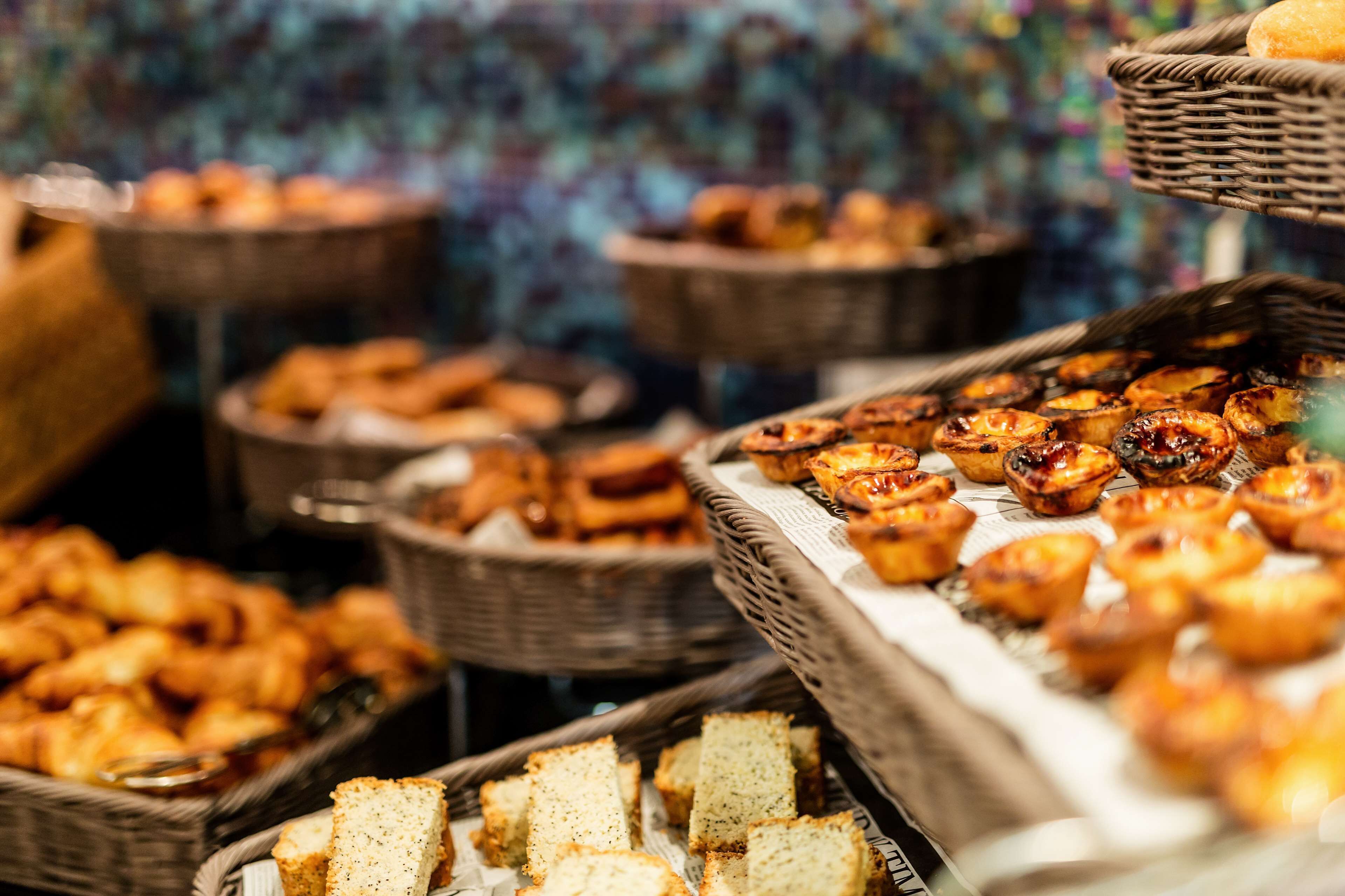 A buffet with various baked goods including bread, pastries, and tarts.