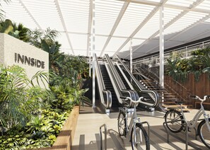 An indoor area with escalators, a bicycle, and a sign reading "INNSIDE".