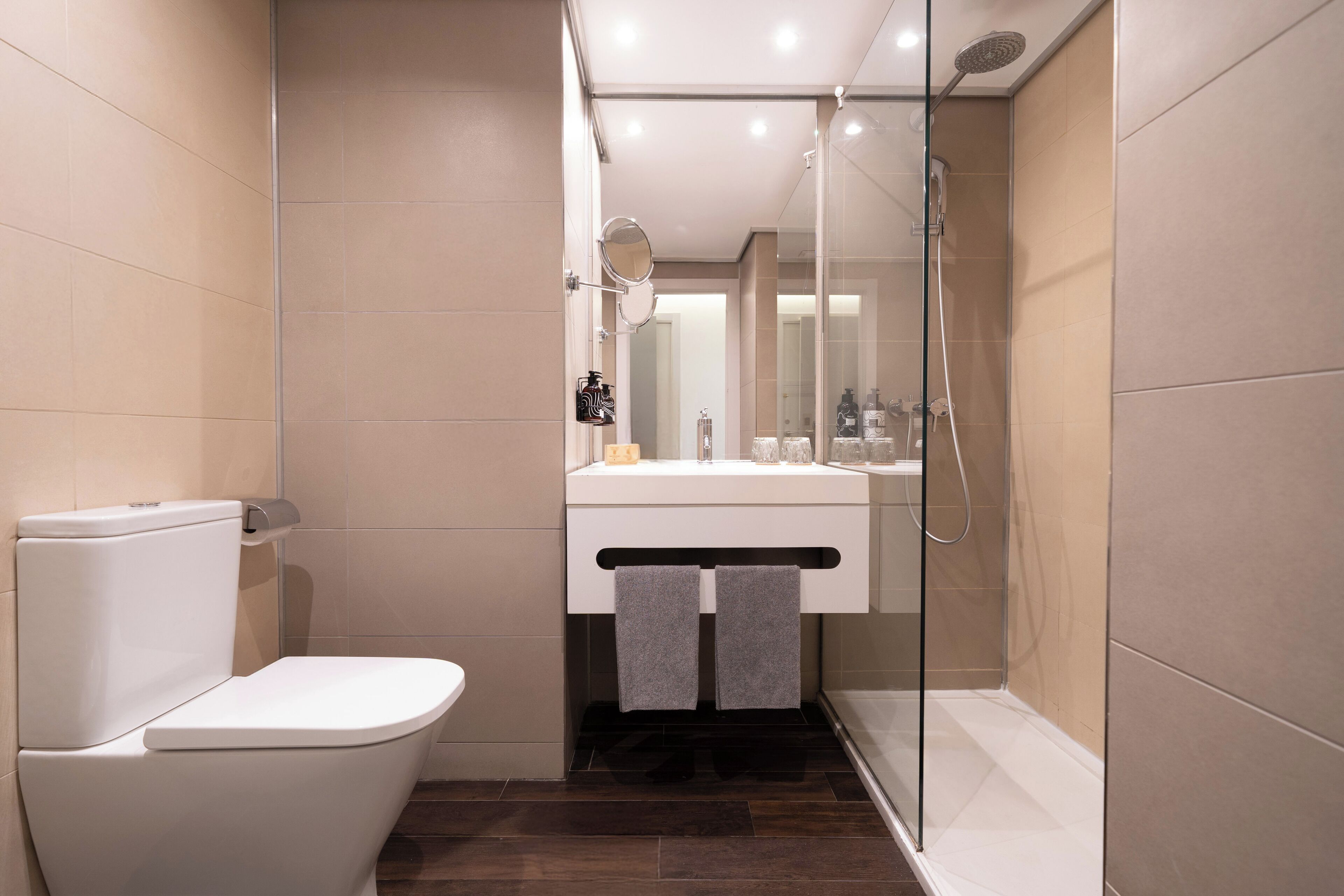 Un baño moderno con inodoro, lavabo y ducha.