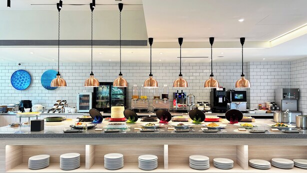 A modern kitchen with multiple pendant lights, a central island with food items, and a refrigerator. - Azure Hotel (Hualien City)