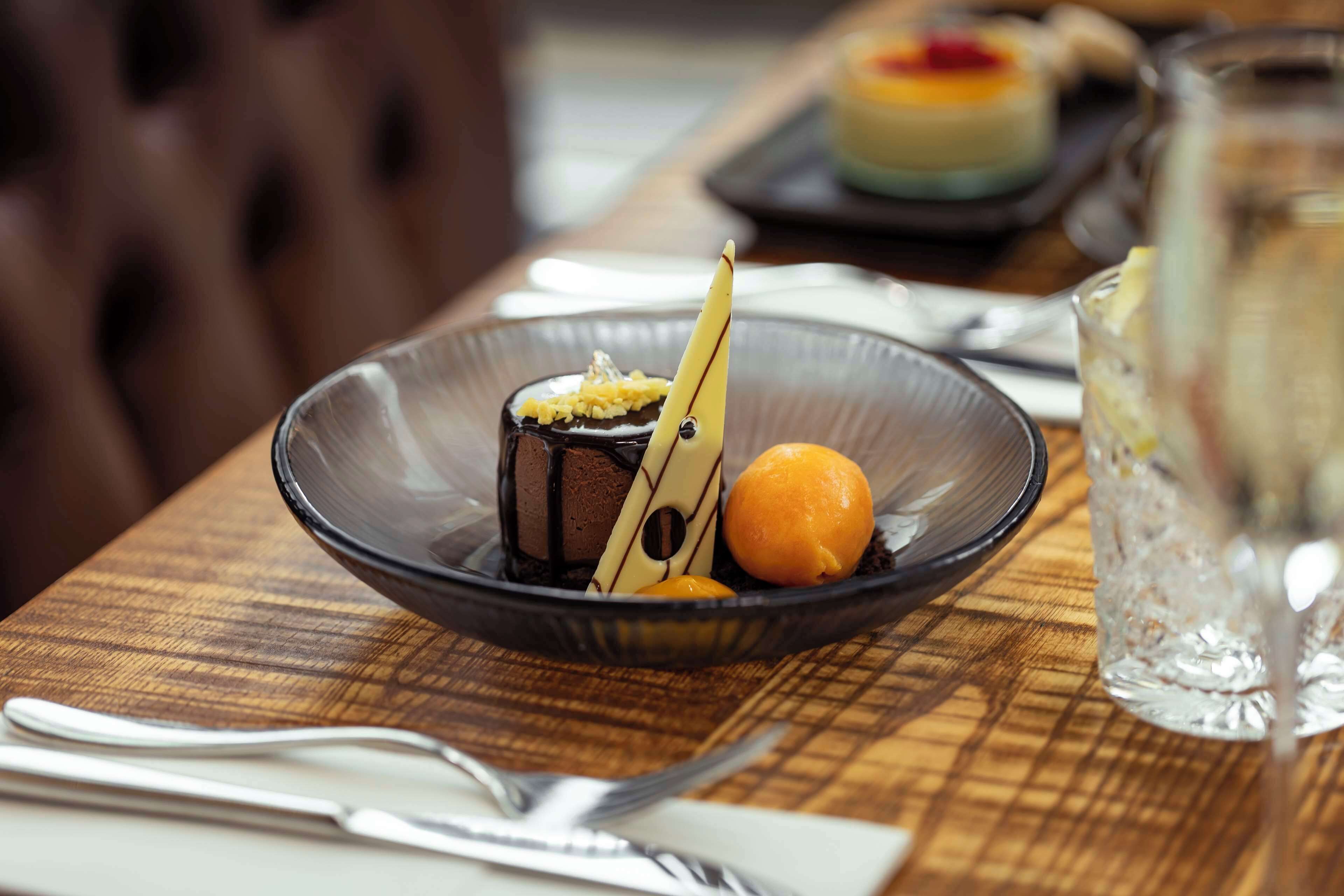 A dessert on a plate with a fork and knife beside it.