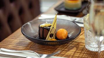 A dessert on a plate with a fork and knife beside it.