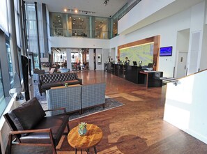 A spacious lobby with a reception desk, seating area, and a large window overlooking the interior. - DoubleTree by Hilton Manchester - Piccadilly (Manchester)