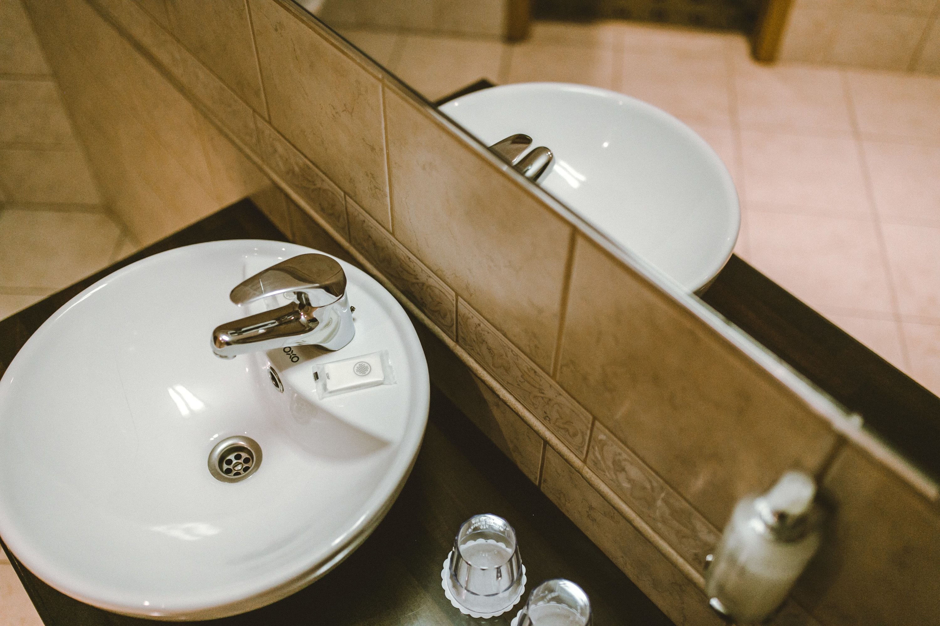 Un baño con lavamanos blanco, un espejo y un inodoro.