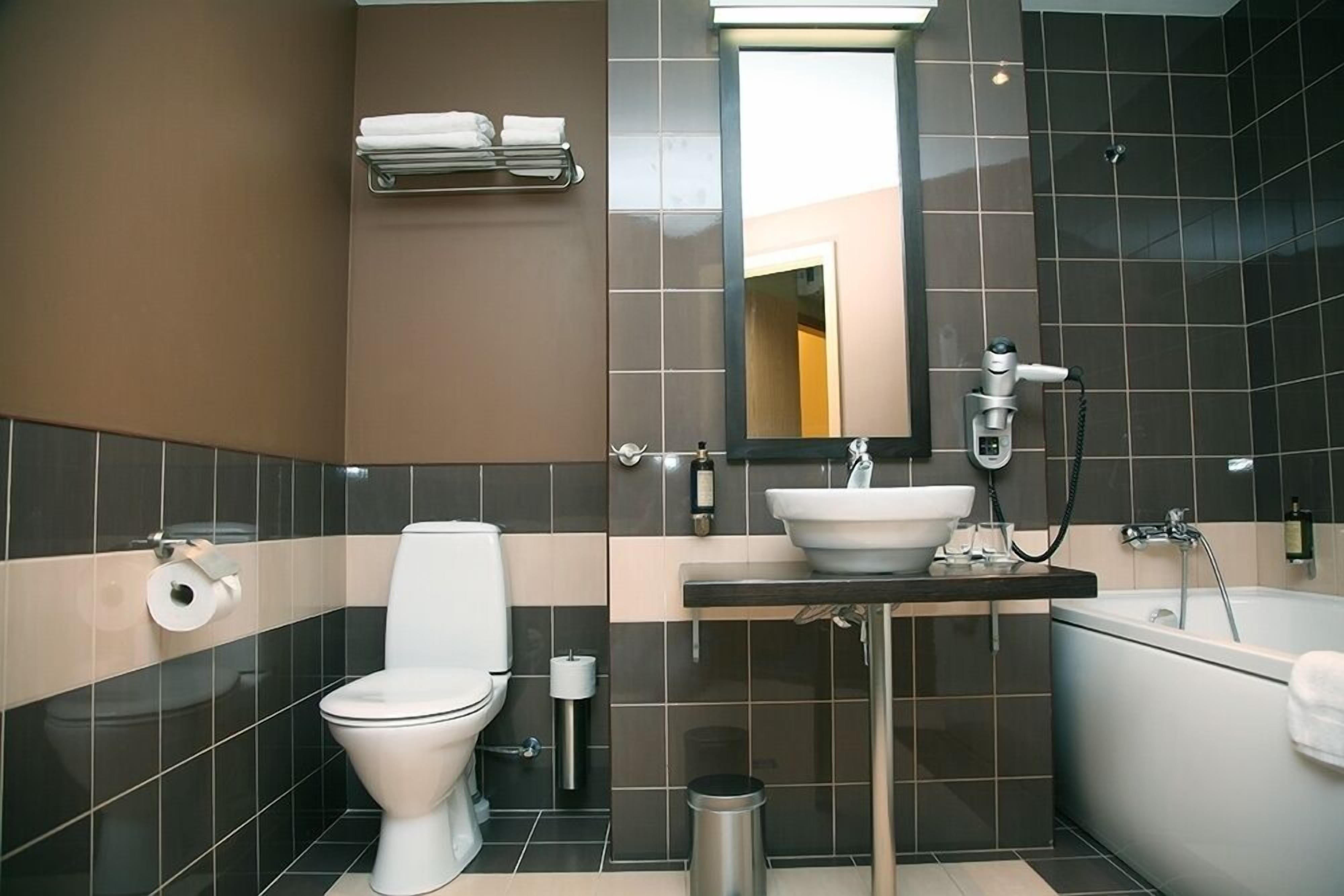 A modern bathroom with a toilet, sink, and bathtub.