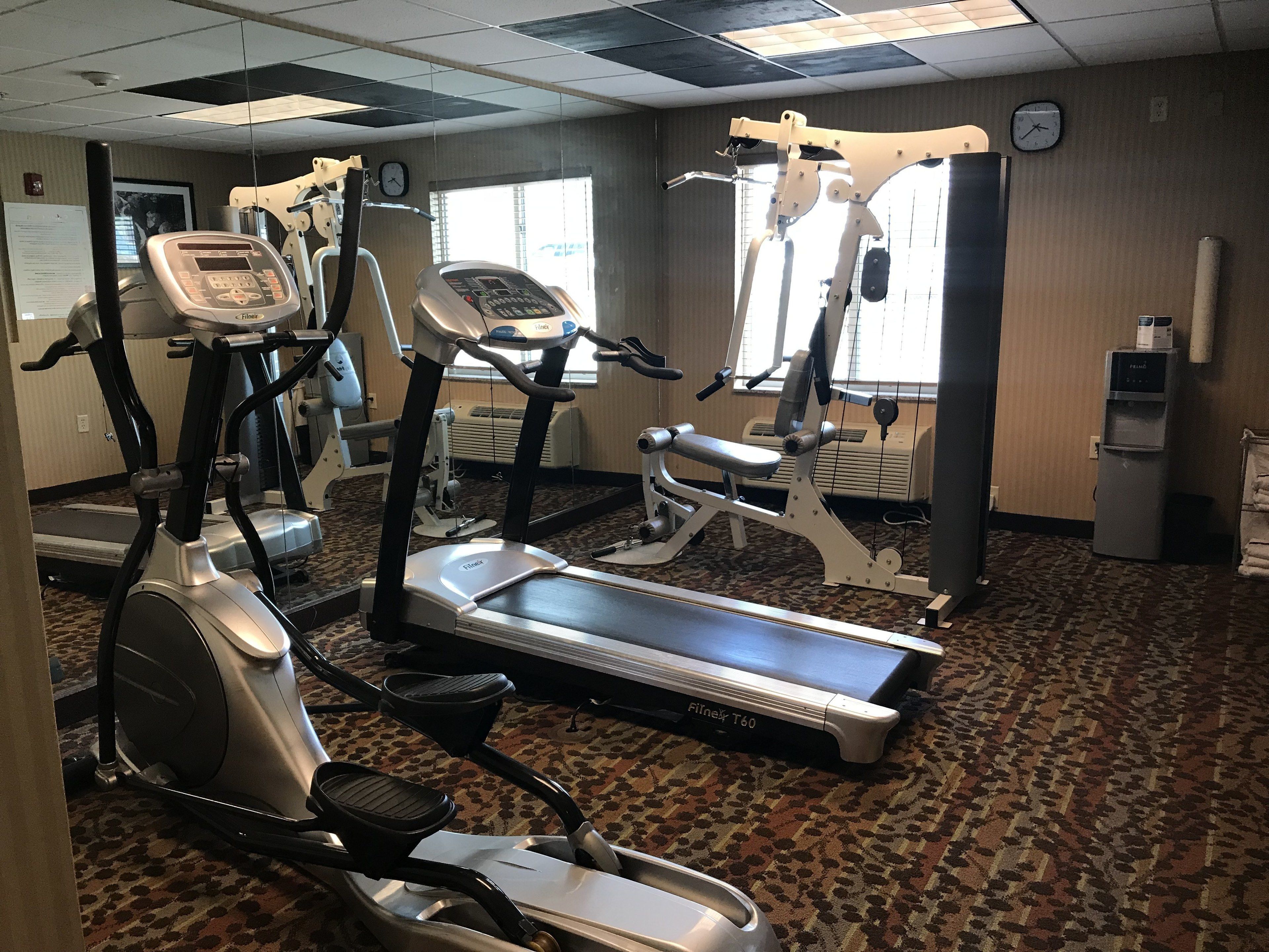 A gym with treadmills, elliptical machines, and a stationary bike.