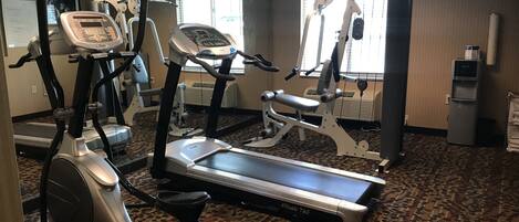 A gym with treadmills, elliptical machines, and a stationary bike.
