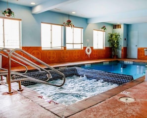 A swimming pool with a ladder, tiled walls, and a lifebuoy.