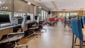 Een moderne kantoorruimte met meerdere werkplekken, ergonomische stoelen en grote ramen die natuurlijk licht binnenlaten.