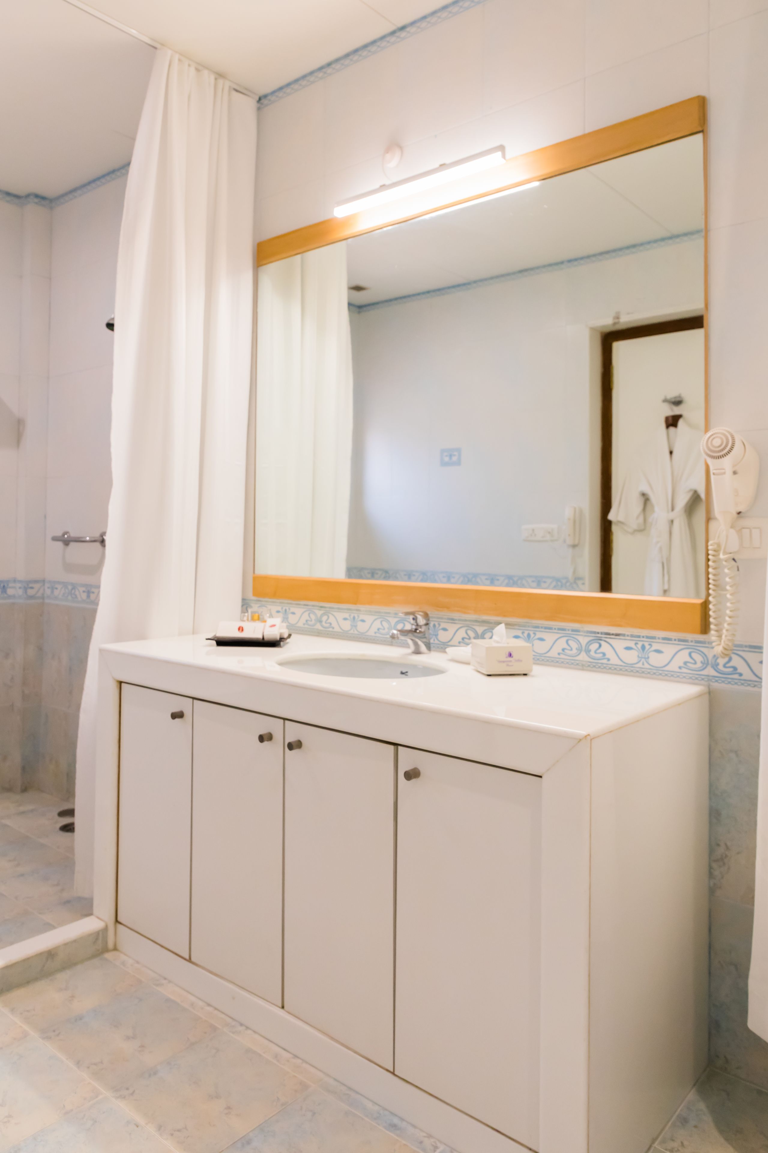 A bathroom with a white sink, a mirror, and a shower area.
