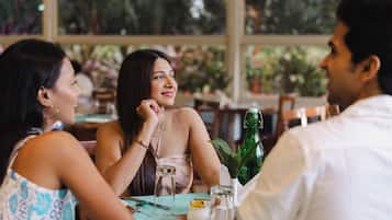 Una mesa de comedor con platos, cubiertos y una botella verde.