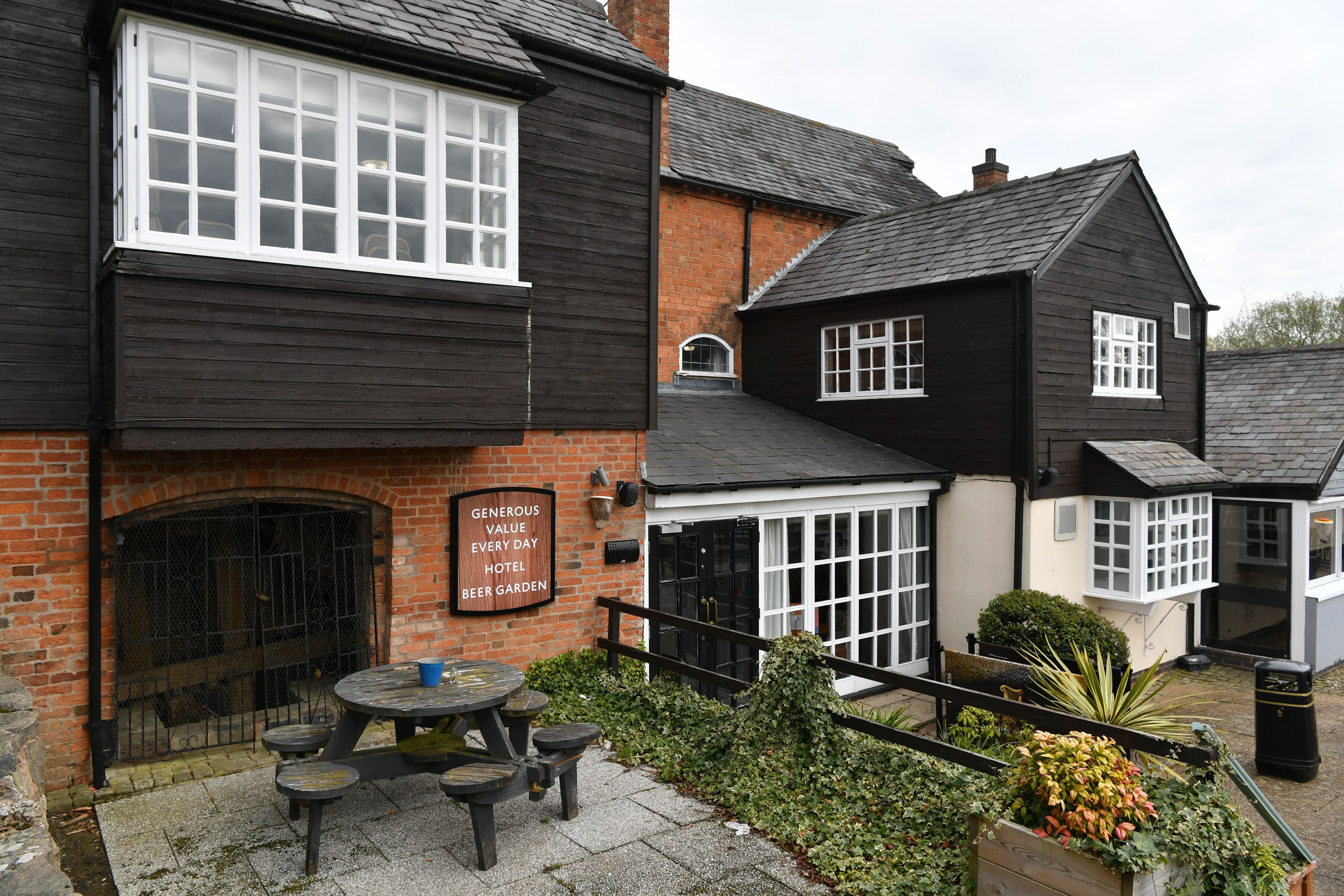 A traditional black and white building with a sign reading "Generous Value Every Day Hotel Beer Garden".