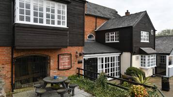 A traditional black and white building with a sign reading "Generous Value Every Day Hotel Beer Garden".