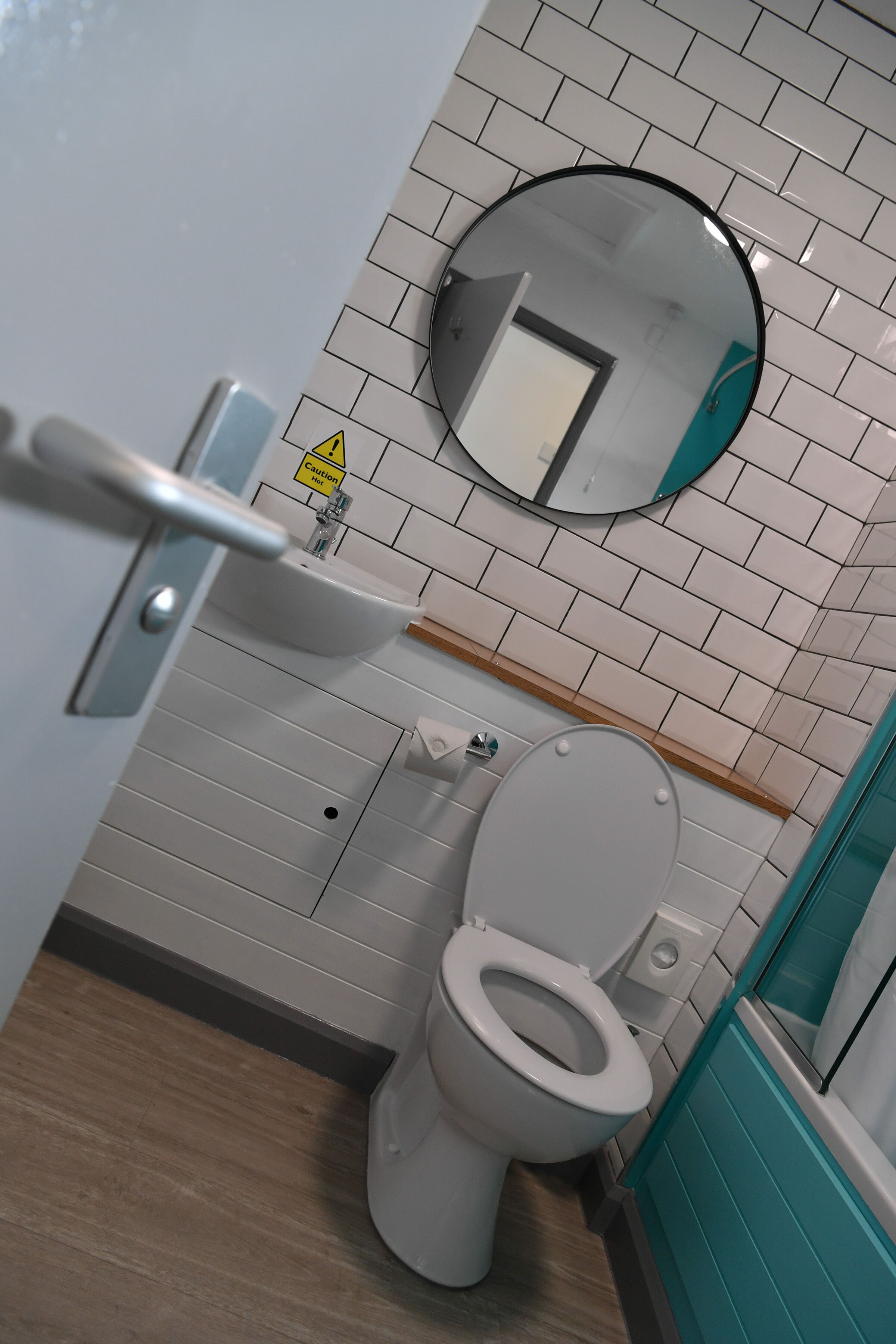 A modern bathroom with a toilet, sink, and mirror.