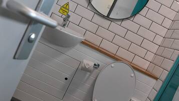 Un baño moderno con inodoro, lavamanos y espejo.