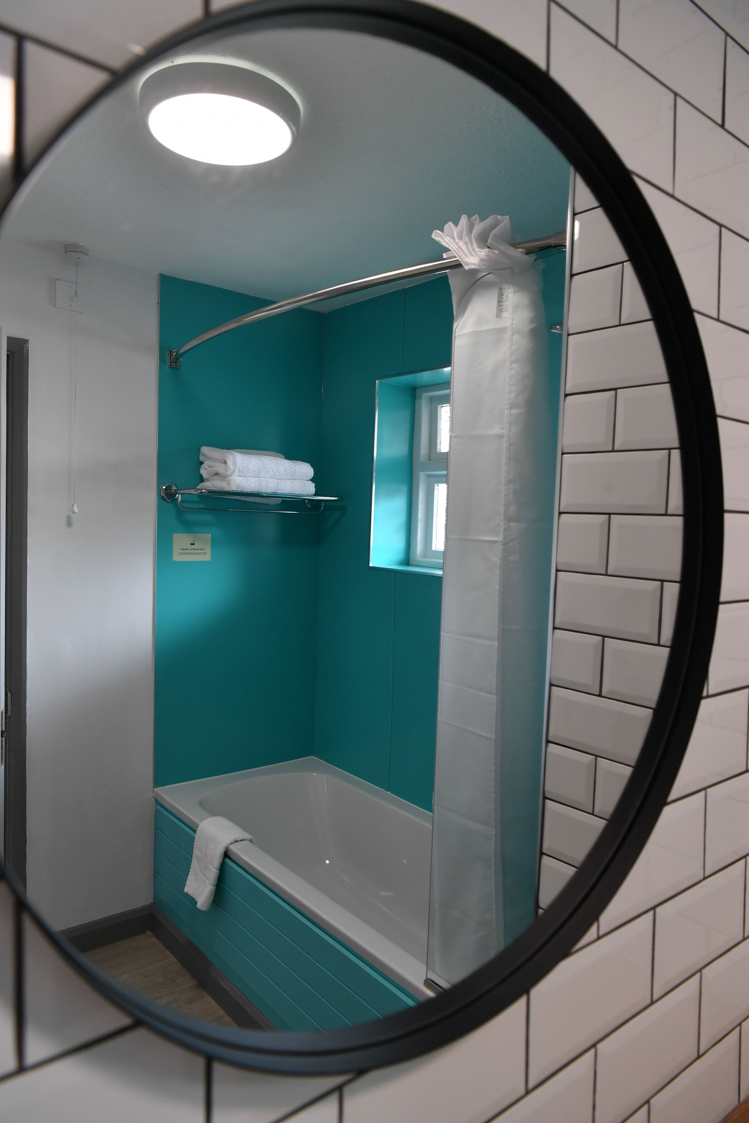 A bathroom with a bathtub, a shower curtain, and a towel rack.