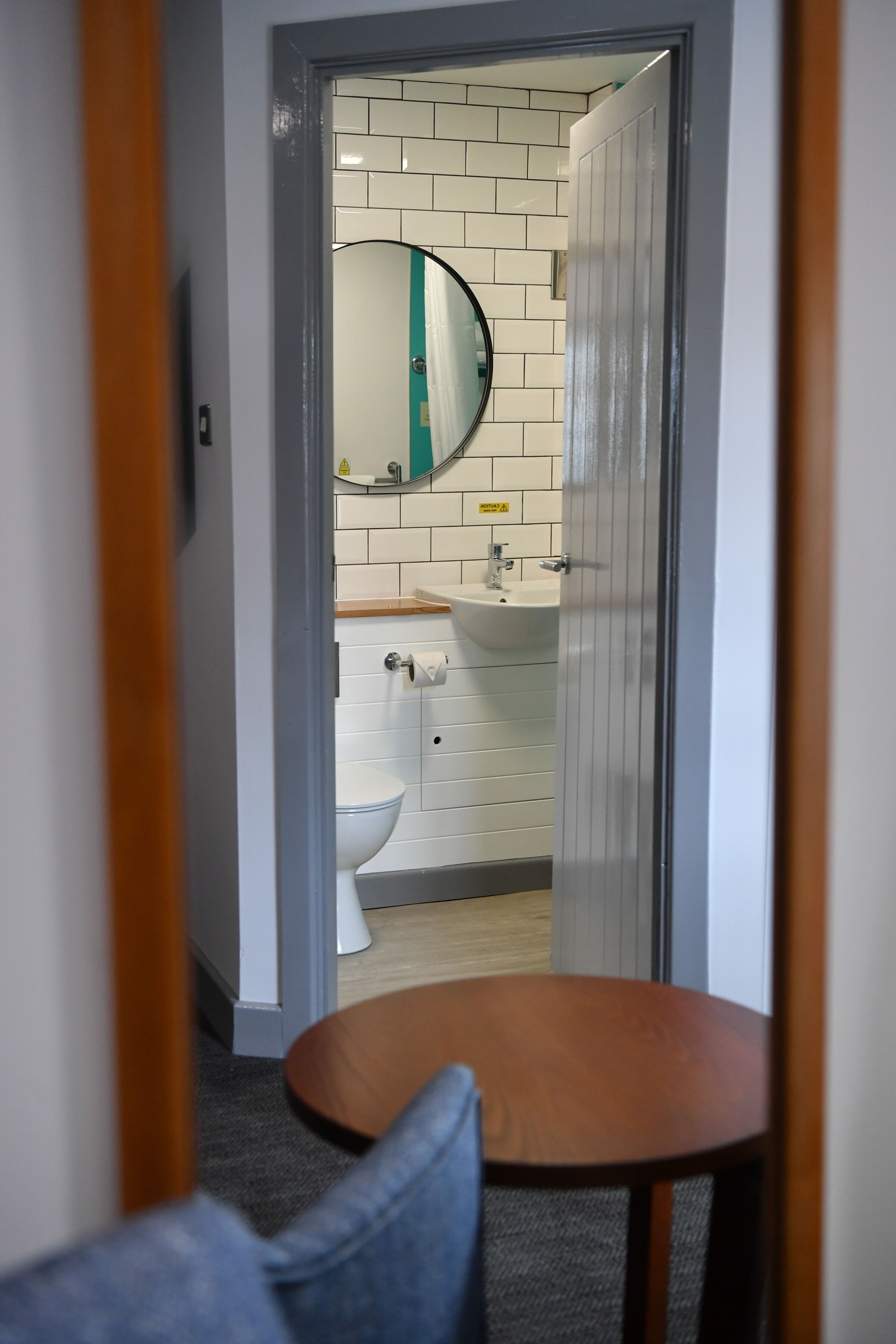 A bathroom with a toilet, sink, and mirror.