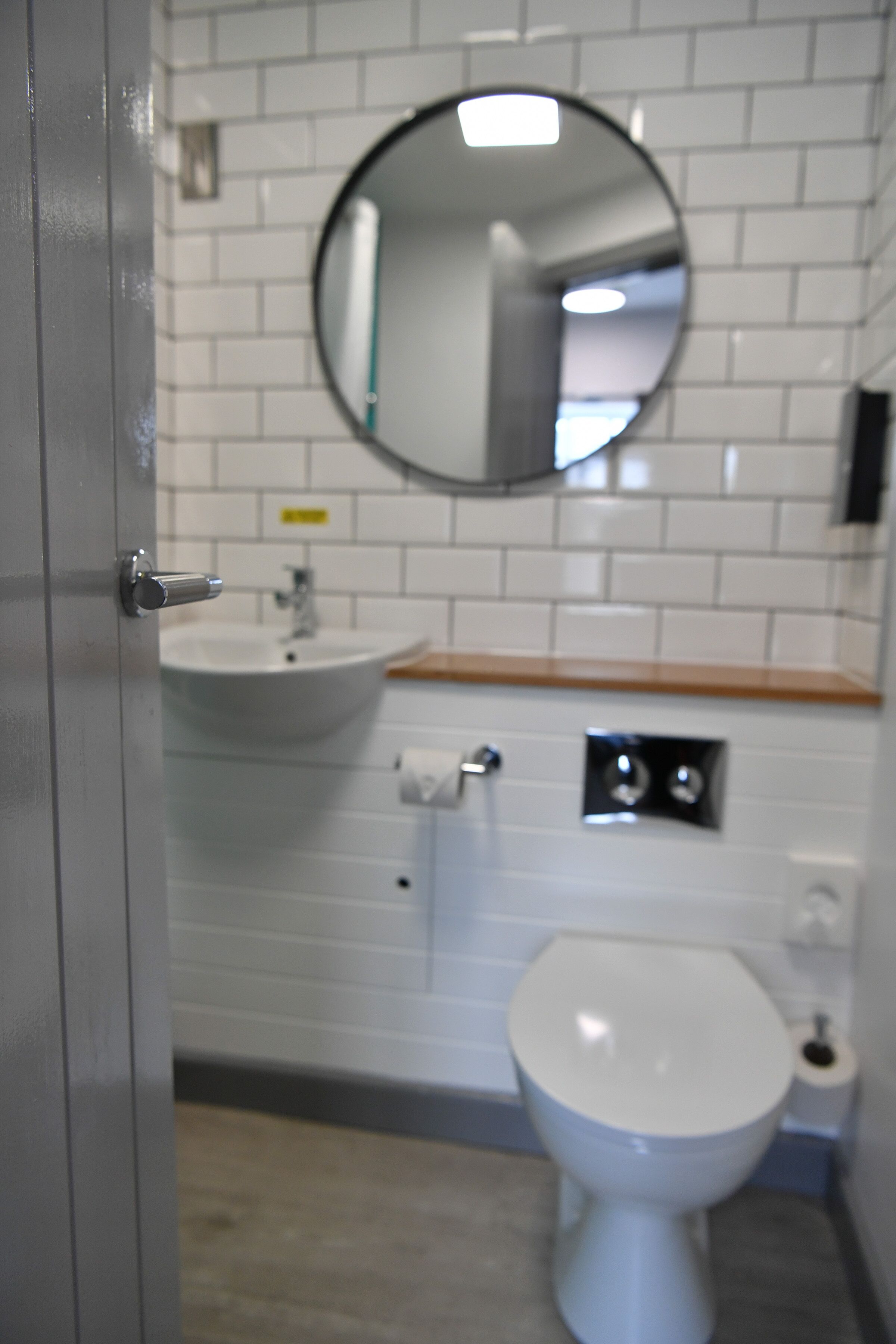 A bathroom with a white sink, a mirror, and a toilet.