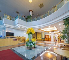 A multi-level atrium with a central floral arrangement, seating areas, and a reception desk.