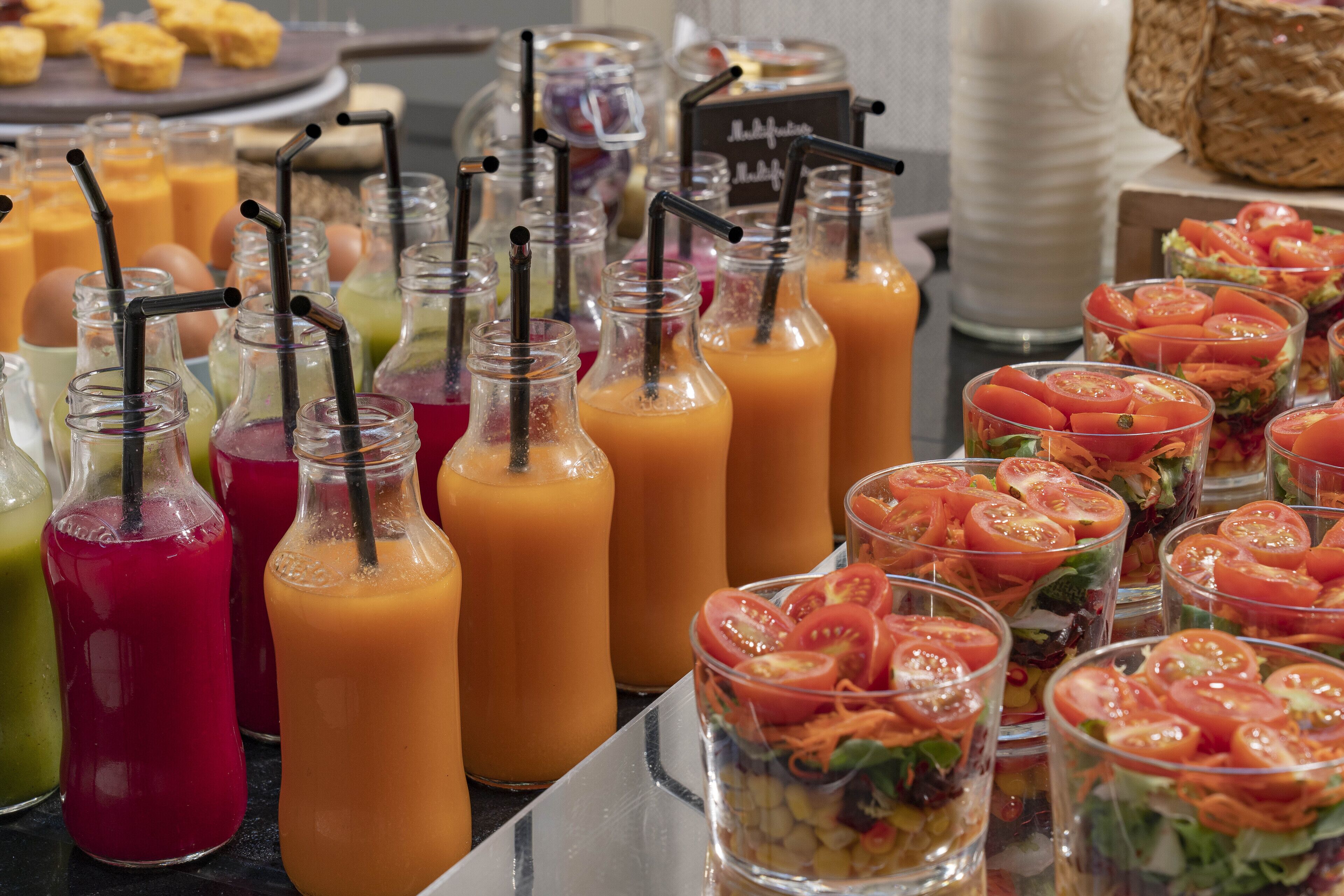 En buffet med forskellige juices og salater.
