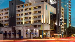 Un hotel moderno con un llamativo letrero que dice 'a loft', varios pisos y una arquitectura que combina vidrio y concreto.